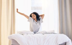 Woman stretching in bed after a restful night of sleep